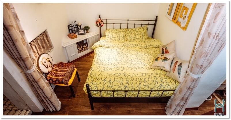 phòng trọ nhỏ đơn giản giường màu vàng, nền gỗ