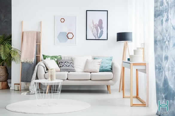 phòng khách chung cư tối giản, hiện đại màu trắng. Sofa trắng dễ thương, thang gỗ trang trí, tranh treo tường màu đen và trắng, đèn cây phòng khách chân gỗ, thảm màu trắng hình tròn, bàn coffe hình tròn màu trắng nhỏ.