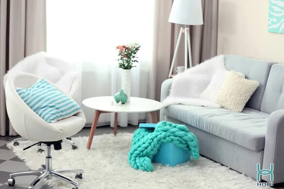 Decor phòng khách chung cư nhỏ gam màu trắng hiện đại. Thảm lông màu trắng, sofa màu xanh pastel nhỏ, đèn cây trang trí và rèm trắng trong suốt.