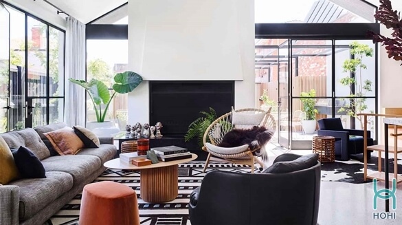 phòng khách hiện đại với thảm kiểu hình học đen trắng, cửa kính và sofa màu xám