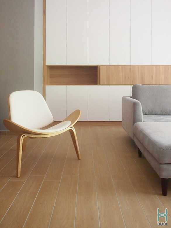 Nội thất phòng khách màu trắng, nâu gỗ dinh giản, không cầu kì. Sàn nhà lót gạch giả gỗ.
