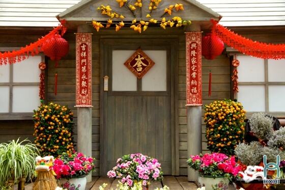 trang trí cổng nhà ngày tết đep với cây quất, hoa, đèn lồng và cây đố.